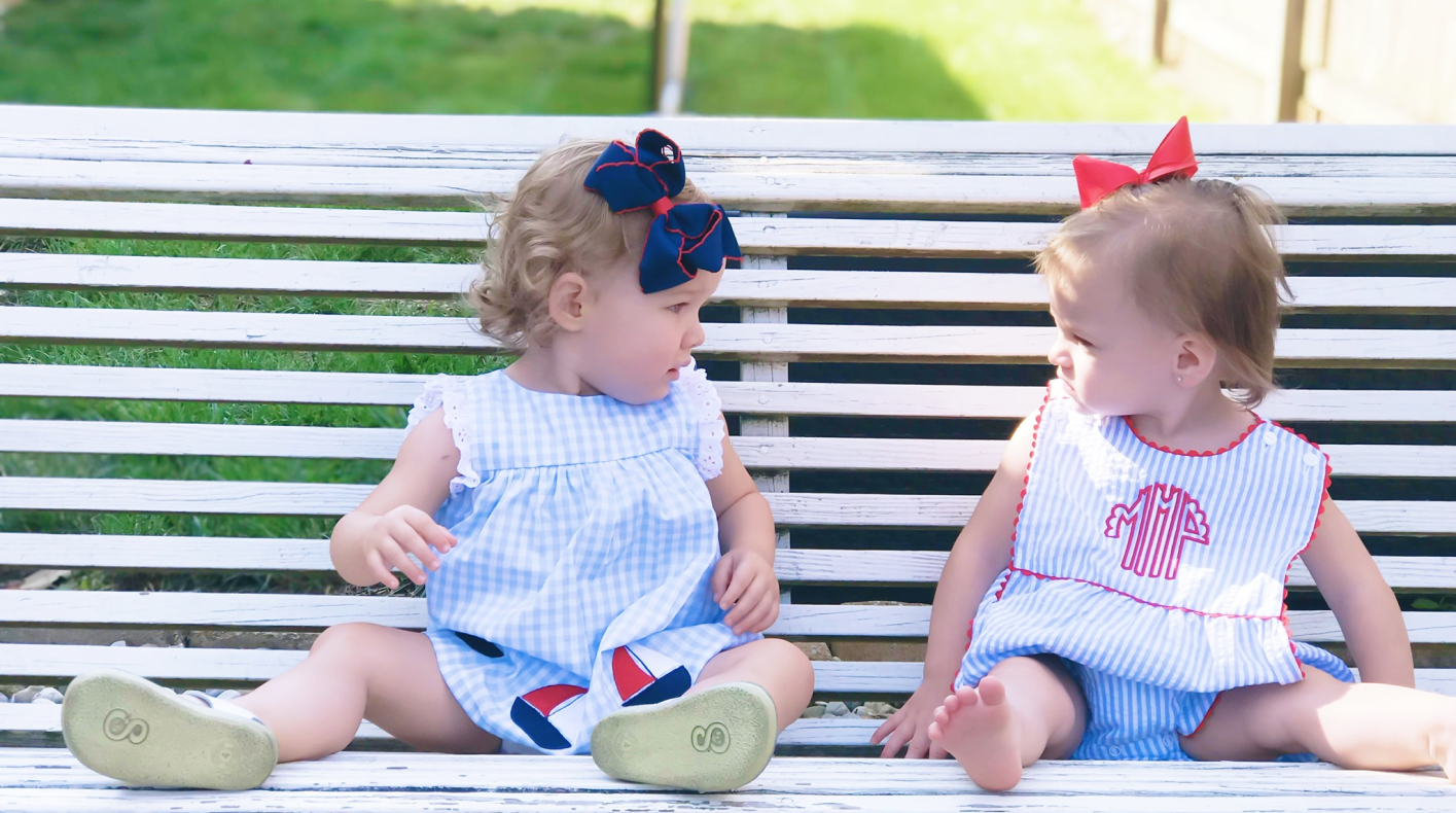 Simply Yours - two babies on bench in ruffle gown